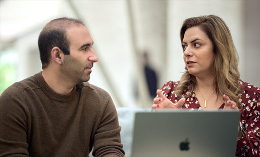 Desireh, sentada delante de un MacBook hablando con un compañero