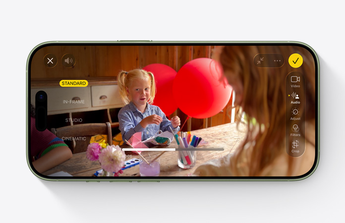 Az iPhone 17 elölnézetből, miközben az Audiomix funkció használatával készül videó egy gyerekről, aki léggömbökkel játszik egy asztalnál